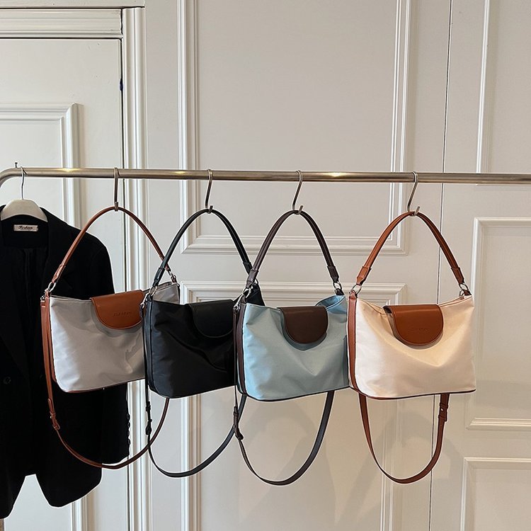 Shoulder bag with curved central closure tab · BG-044